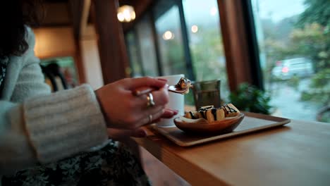 woman enjoying dessert and drink in a cozy cafe