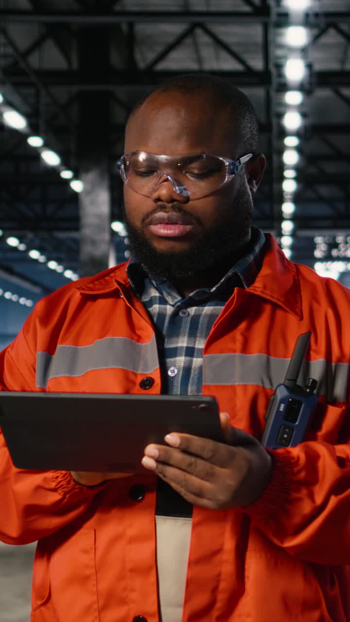 Vertical Video Black professional technician checking workshop equipment in a warehouse