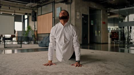 businessman stretching in modern office