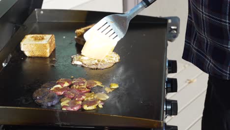 adding cheese to the fried eggs and ham to make a texas toast breakfast sandwich