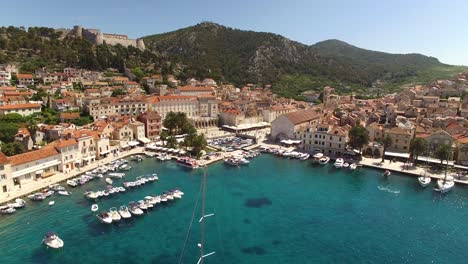 Una-Vista-Aérea-Muestra-Los-Veleros-Acercándose-Al-Puerto-De-Hvar,-Croacia.