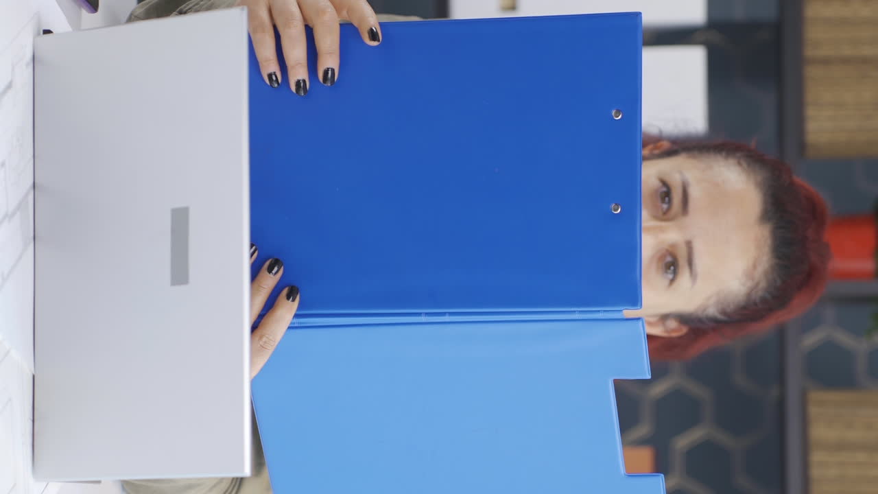 Vertikální video veselé podnikatelky pracující na spisech.
