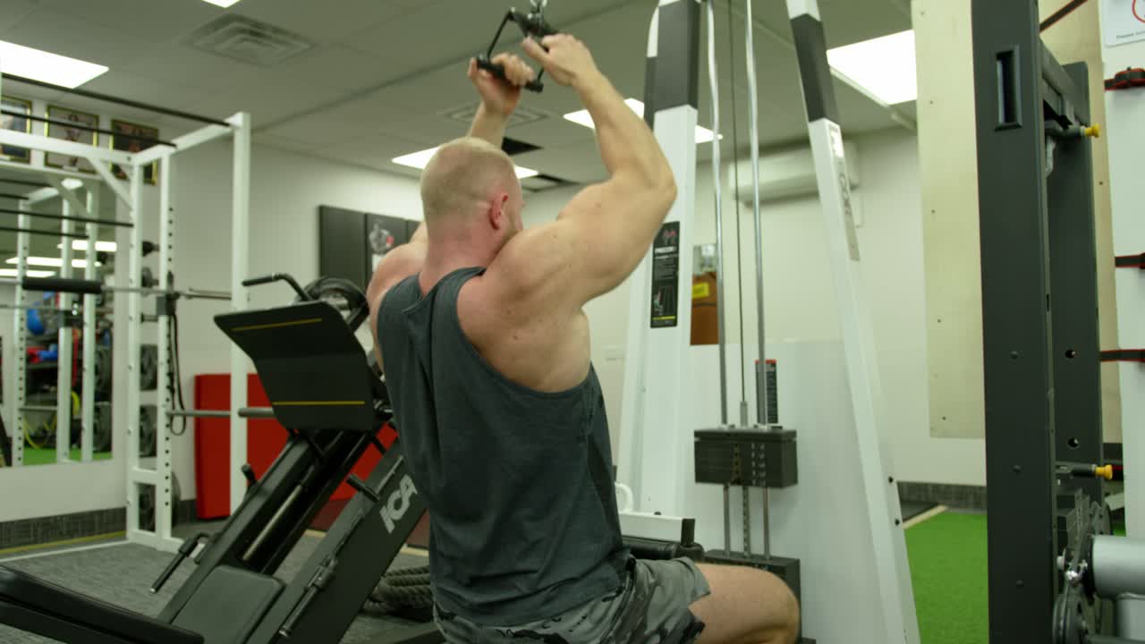 Young Adult Man Strenuously Working Out at Gym