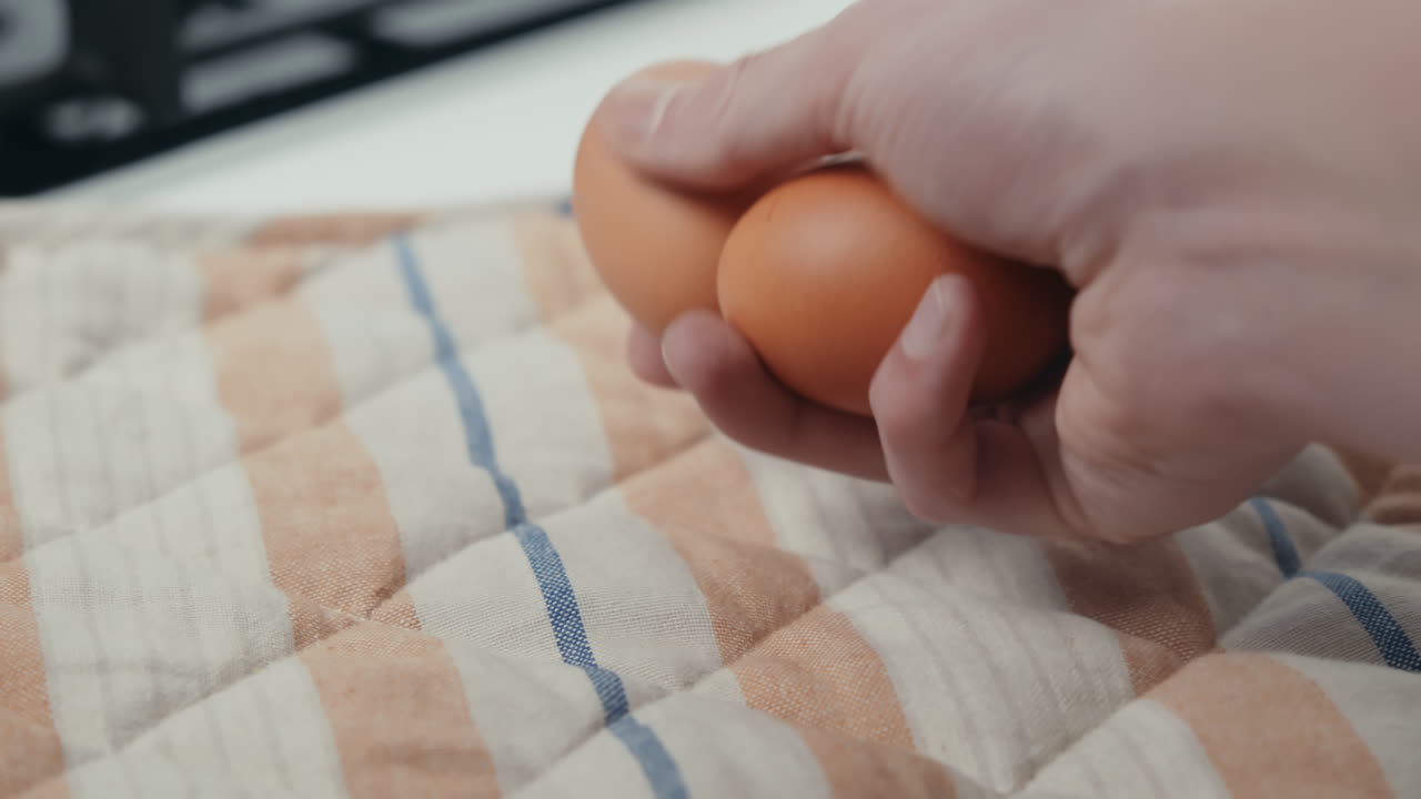 Hand placing two organic eggs on a cloth