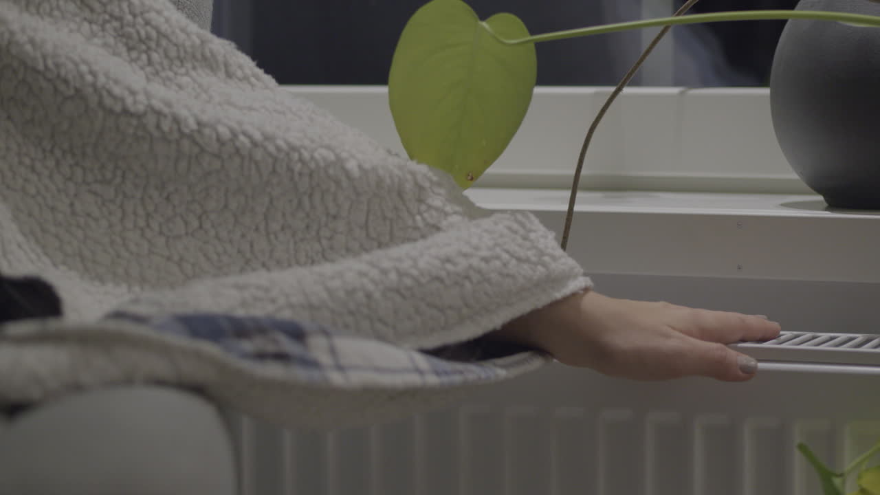 겨울 실내 온도: 차가운 손으로 라디에이터의 온도를 확인합니다.