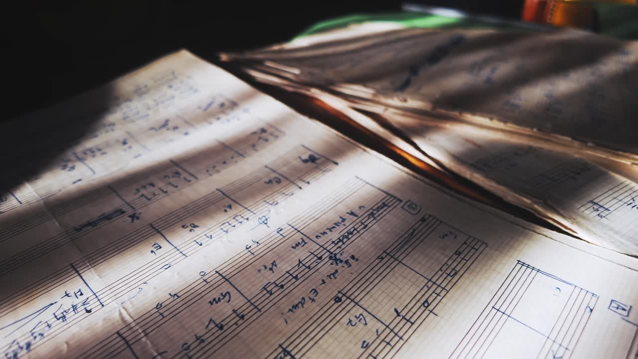 Handwritten classical music composition on aged score sheets revealed in sunlit shadows