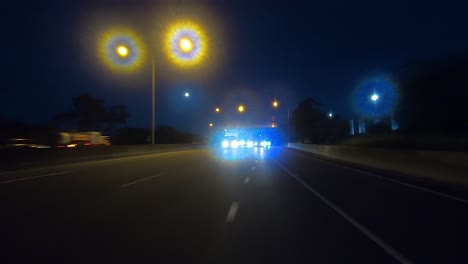 Punto-De-Vista-De-Conducción-Nocturna-Mirando-Hacia-Atrás-Para-El-Reemplazo-De-La-Pantalla-Verde-De-La-Escena-Interior-Del-Automóvil:-Conducir-A-Lo-Largo-De-Una-Autopista-O-Autopista-Suburbana-Concurrida,-Salir-Por-Un-Carril-De-Acceso-Oscuro