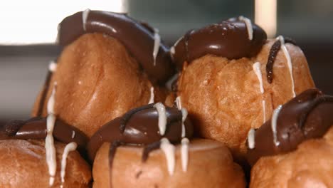 close up of profiteroles choux pastry with whipped cream filling and chocolate top