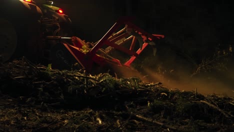 trituradora forestal procesa restos de árboles después de la infestación de escarabajos de corteza por la noche