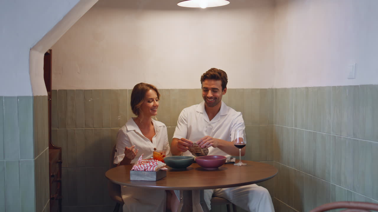 Coppia innamorata in un appuntamento romantico al ristorante. Uomo felice che prende il pane a cena