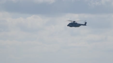 nh90 military helicopter flying against cloudy sky backdrop tracking