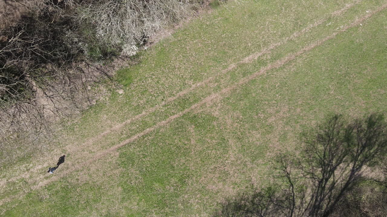 Aerial 4K Drone Shot Of Female Exercise Fitness Model Running Through A Park. Outdoor Cardio Workout Health And Fitness Shoot.