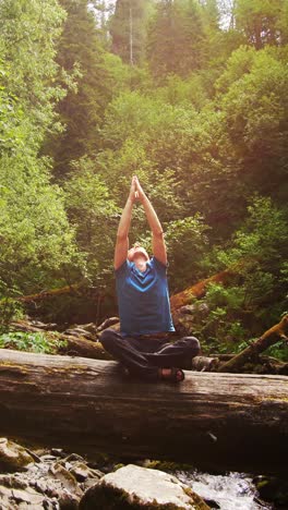 man meditating in forest