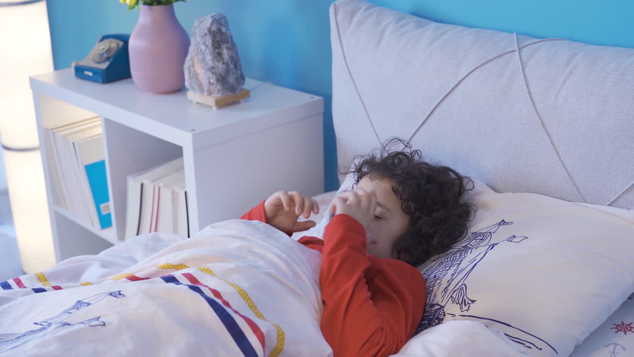악몽을 꾸는 소년은 두려움으로 침대에서 깨어납니다.
