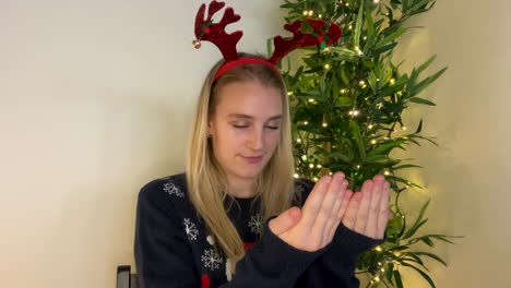 young woman on christmas video call acting out word during charades game