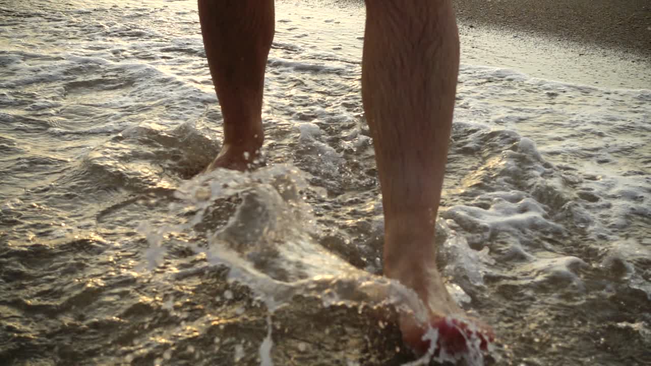 L'uomo cammina sulla spiaggia sabbiosa. Rallentatore