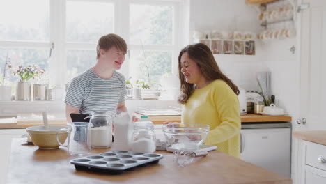 young downs syndrome couple having fun baking in kitchen at home