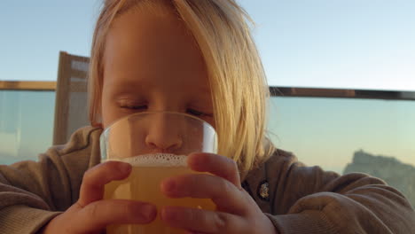 Niño-Divertido-Bebiendo-Jugo-Al-Aire-Libre