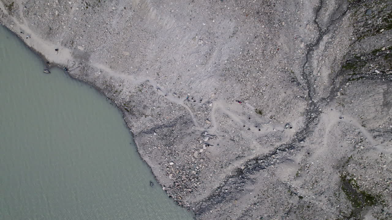 vista aérea de arriba hacia abajo de la ruta de senderismo a lo largo del lago glaciar pasterze en el parque nacional high tauern, austria