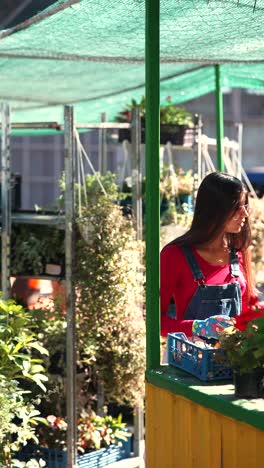 mujer regando plantas en un mercado callejero