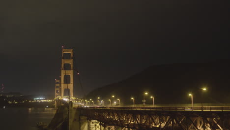 加州舊金山的金門大橋的側邊在夜晚時隔時間,因為交通穿過大橋