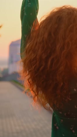 woman in a green dress running at sunset
