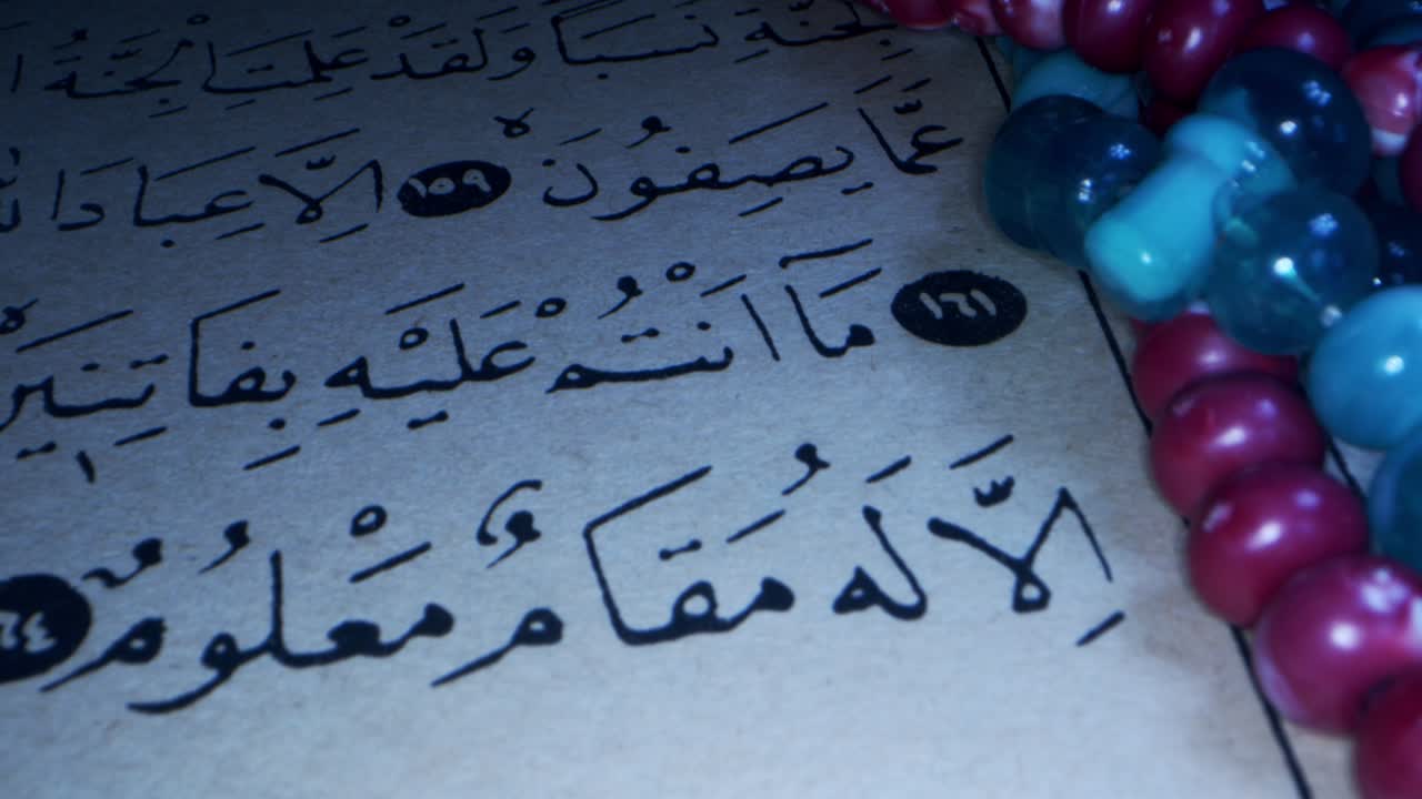 una página del libro del sagrado corán y cuentas