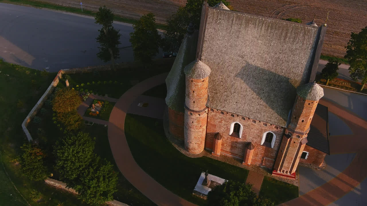 Aerial drone view of historic brick church and chapel surrounded by countryside landscape in Belarus