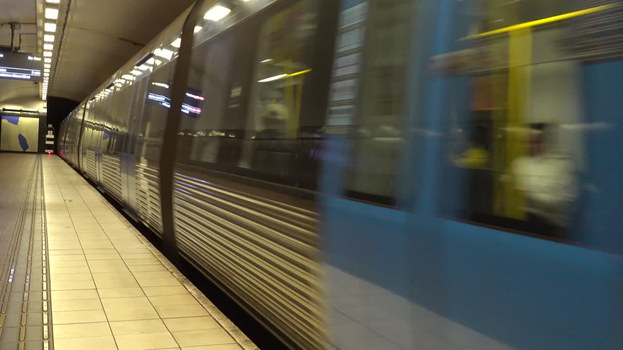 Treno della metropolitana blu in arrivo su una banchina di stazione sotterranea