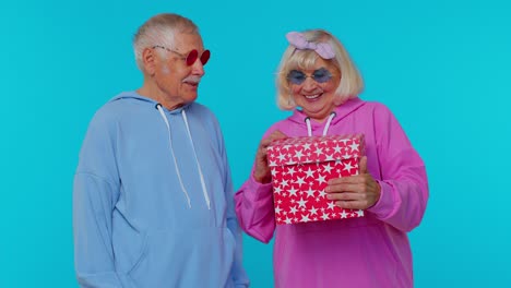 pareja de ancianos alegre hombre mujer abuelos abriendo caja de regalos, sonriendo alegremente sorpresa de cumpleaños