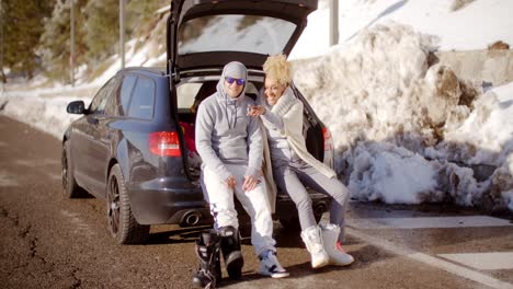 Couple-talking-as-they-put-on-skiing-boots