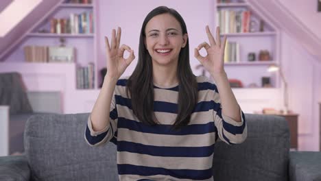 una chica india feliz mostrando una señal de bien