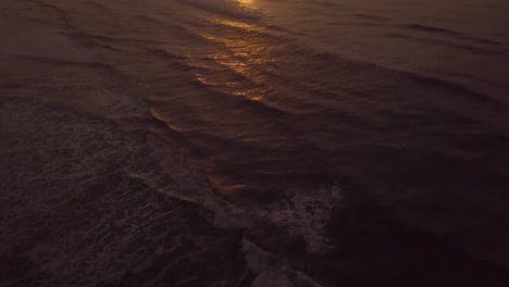 Slow-motion-aerial-shot-of-waves-in-Itanhaem-beach-in-sunrise,-perfect-sky