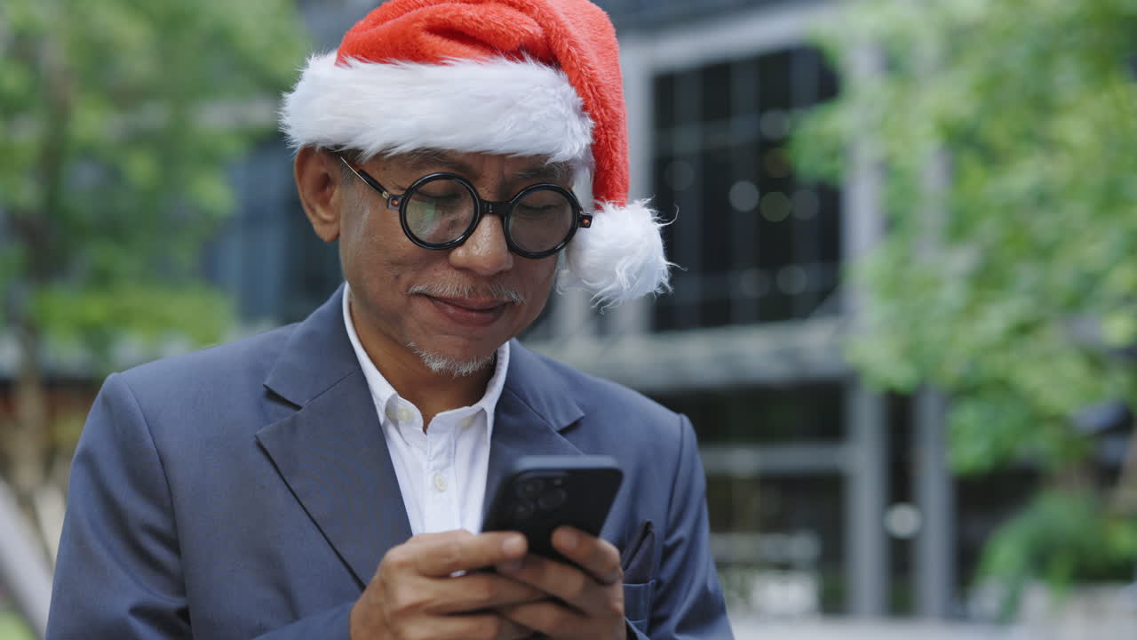 Man in Santa Hat using Smartphone Outdoors