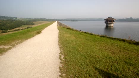 extra-wide-shot-of-Carsington-Water-Carsington-Water-Valve-Tower,-Draw-Off-Tower-and-the-dam-path