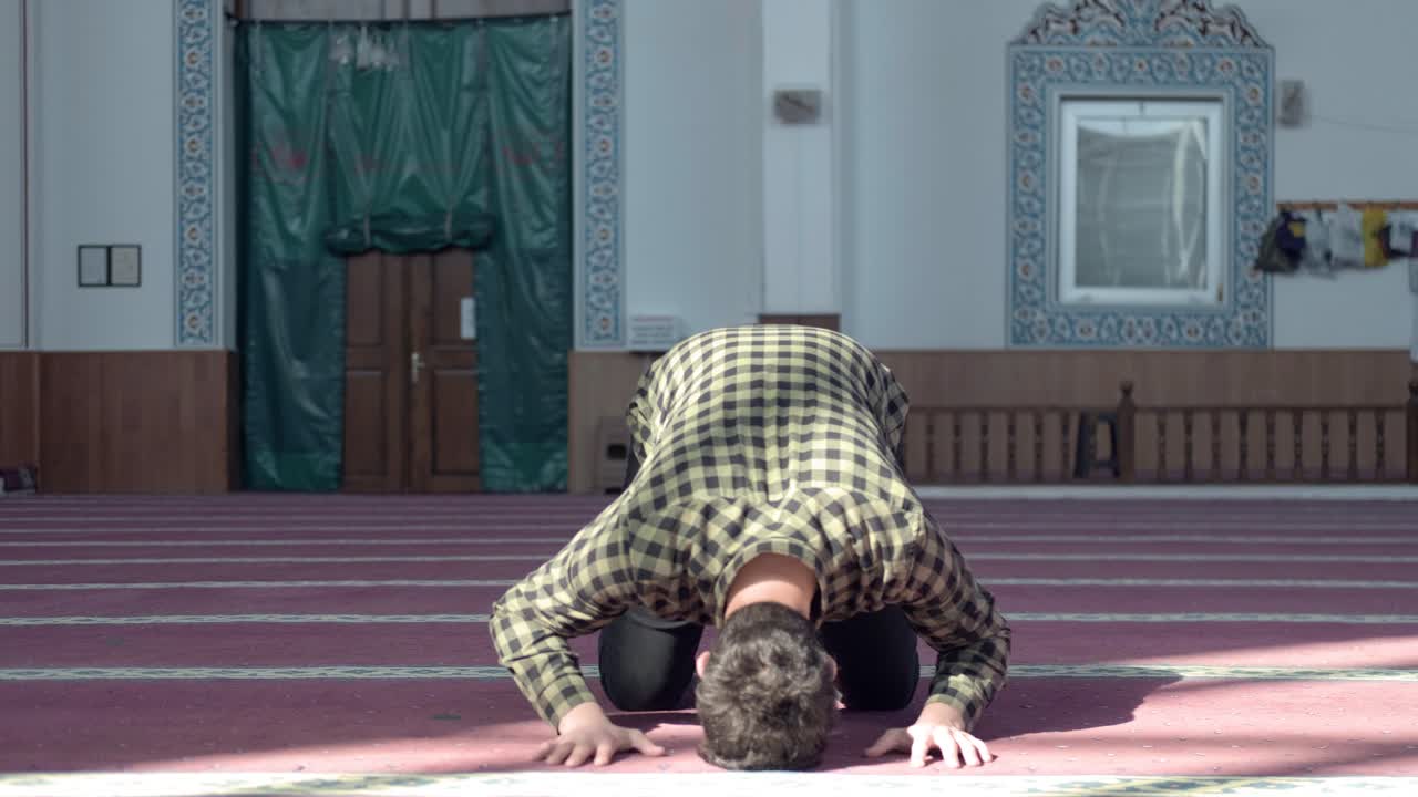 모스크에서 기도하는 가면을 쓴 청년