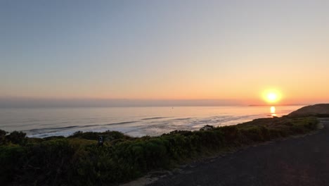 vista del atardecer sobre el océano y la carretera costera