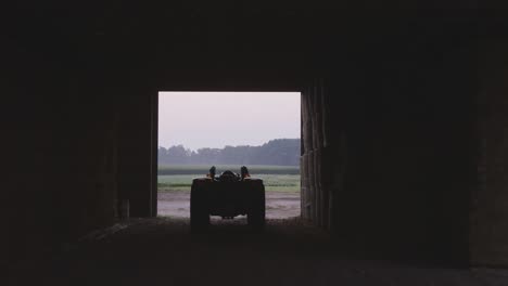 reverse shot of artistic view of tractor in shadow and light inside a barn