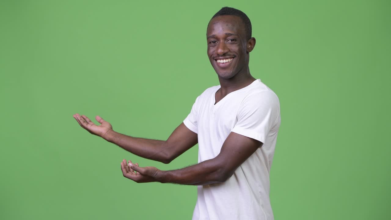 Young African man smiling while showing something