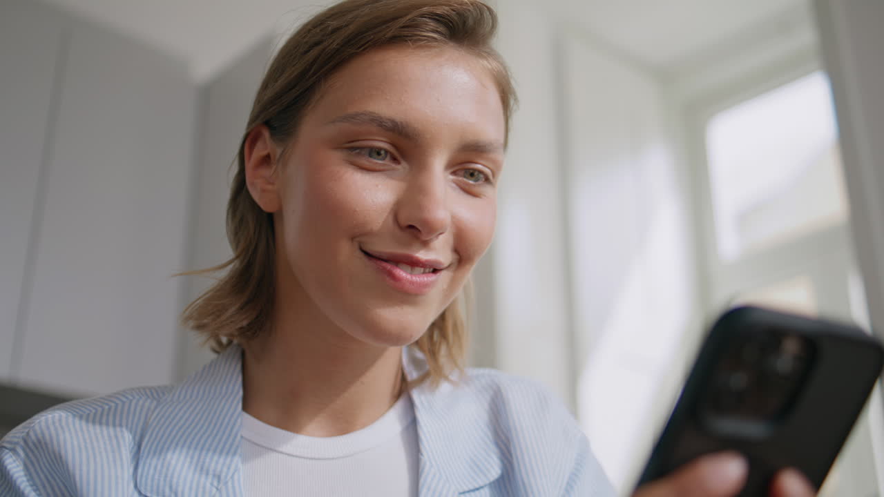 Content woman sending sms chatting in morning closeup. Smiling lady look mobile