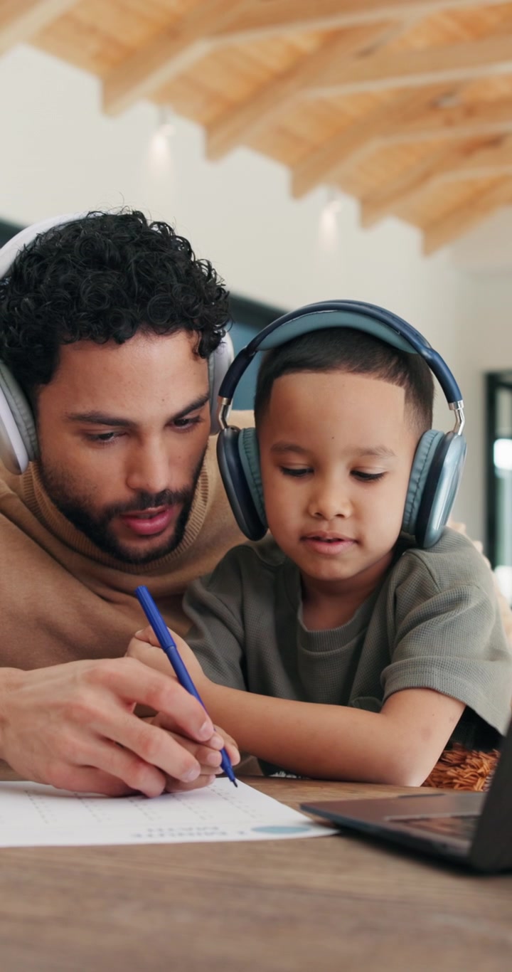 Father Helping Young Son With Schoolwork at Home