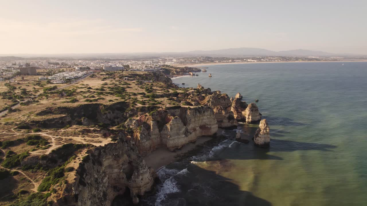 Luftaufnahme, die die schillernde Küste von Lagos an der Algarve bei goldenem Sonnenuntergang verfolgt