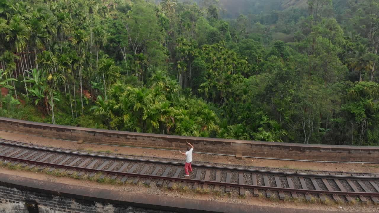Veduta aerea di un uomo che balla vicino al Ponte dei Nove Archi con campi di tè a Ella, Badulla, Sri Lanka.