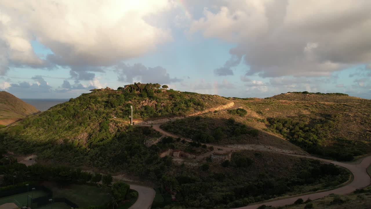 해양 지평선 위의 무지개와 함께 영국 버진 아일랜드의 언덕과 도로의 공중 뷰, 드론  ⁇