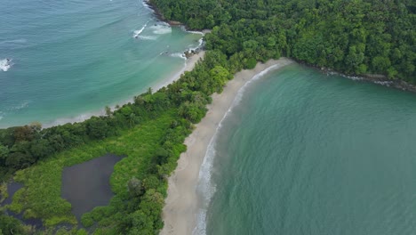 Toma-Aérea-De-La-Playa-En-Forma-De-Cola-De-Ballena-En-El-Parque-Nacional-Manuel-Antonio,-Costa-Rica