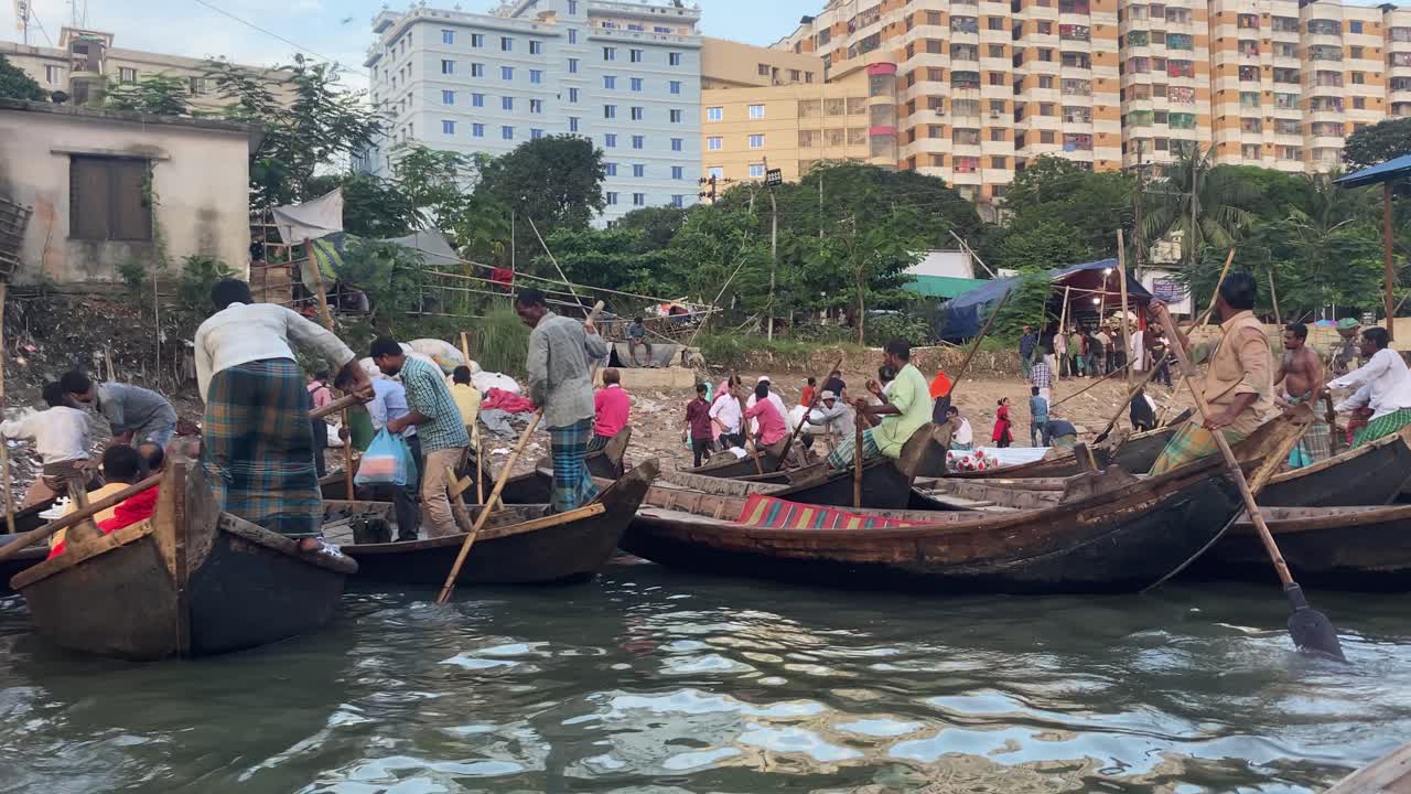 A lot of trade passenger boats wait in the water as people load their boats.