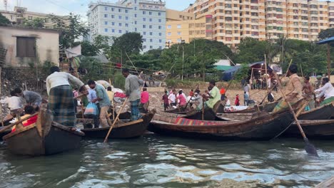a lot of trade passenger boats wait in the water as people load their boats.