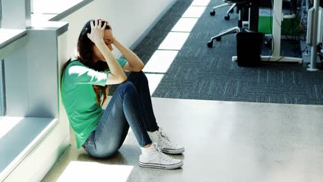 depressed female executive sitting on the floor