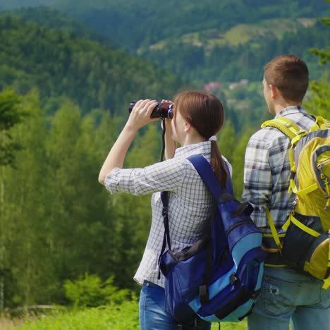 young tourists in the forest looking through binoculars 1