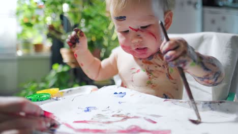 baby paints, loop. loopable footage of the infant baby girl painting at home